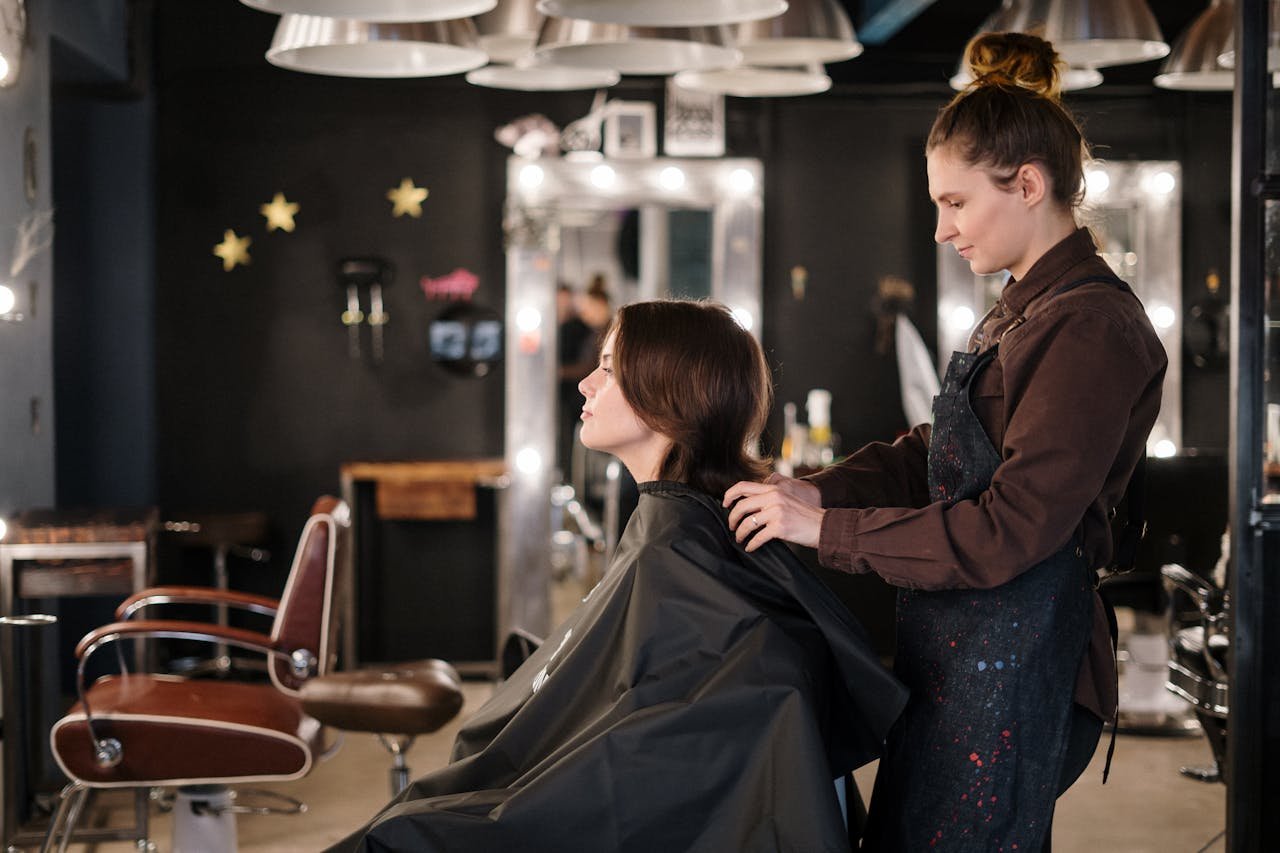 Home A hairstylist trims a clients hair in a modern salon setting, capturing a moment of focus.
