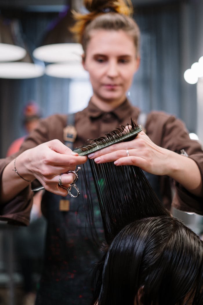 A hairstylist expertly cutting a clients hair in a modern salon setting.