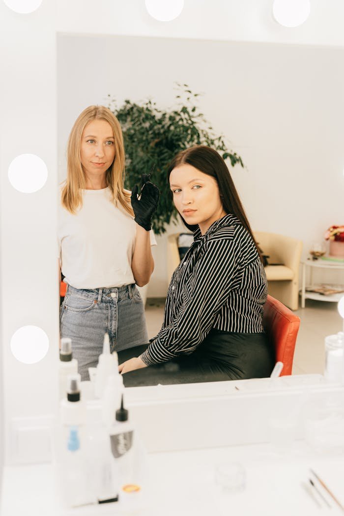 Home Makeup artist applying cosmetics to client in a modern salon with vanity mirror.